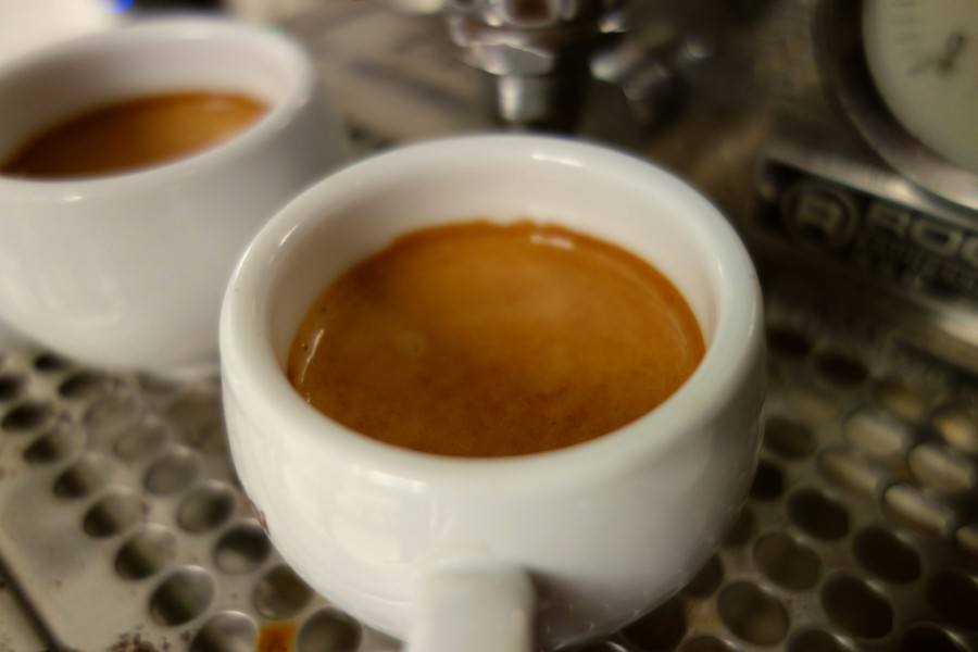 Two cups of coffee sitting on top of a machine in Croatia.