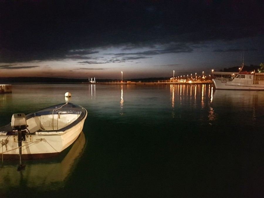 A boat docked in the water at night, providing a serene stay experience near Pula Hotels.