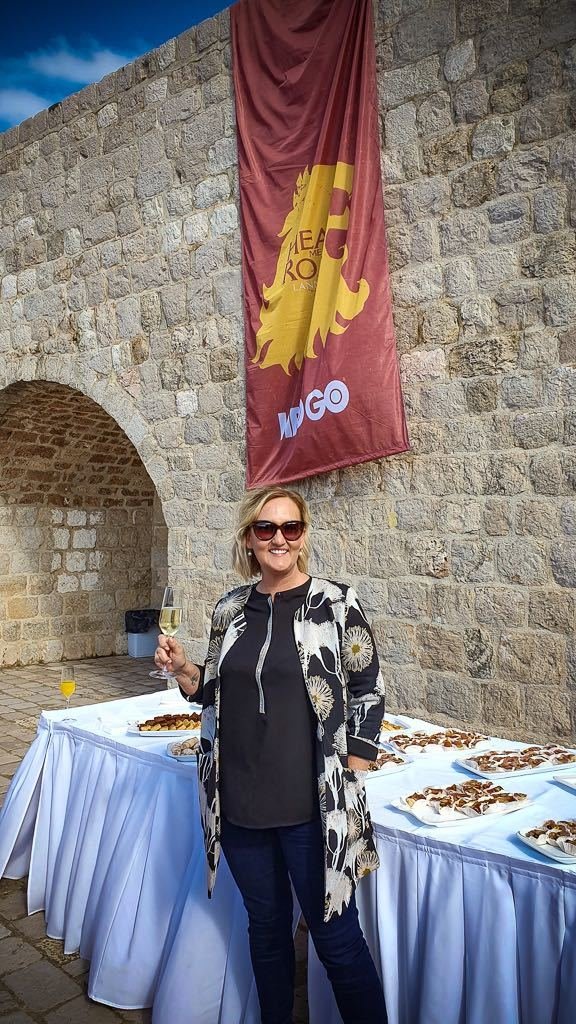 A woman standing in front of a table with a Game of Thrones banner.