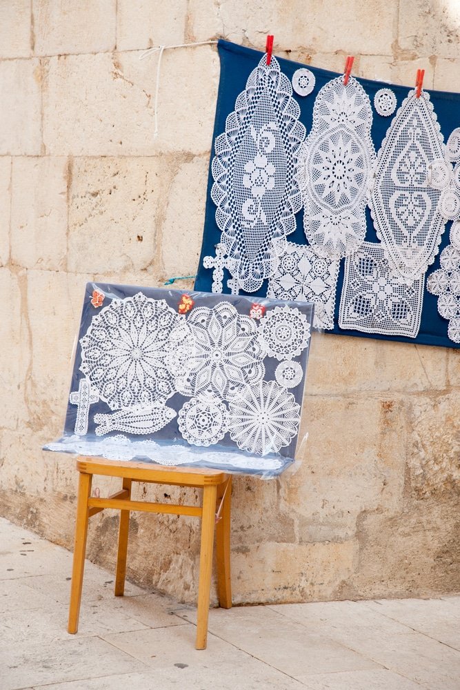 A wooden chair beside a stone wall at Pag Lace festival in Croatia.