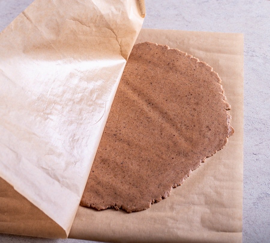 A piece of dough on a piece of brown paper, reminiscent of traditional Croatian Paprenjaci - delicious black pepper cookies.