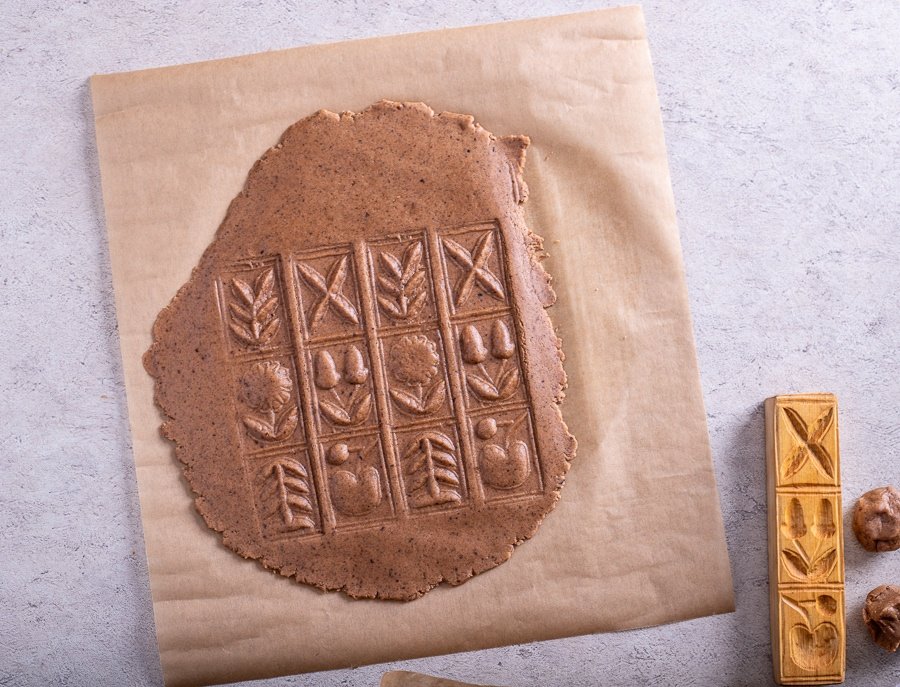 A Croatian Paprenjaci cookie with a design on it next to a piece of paper.