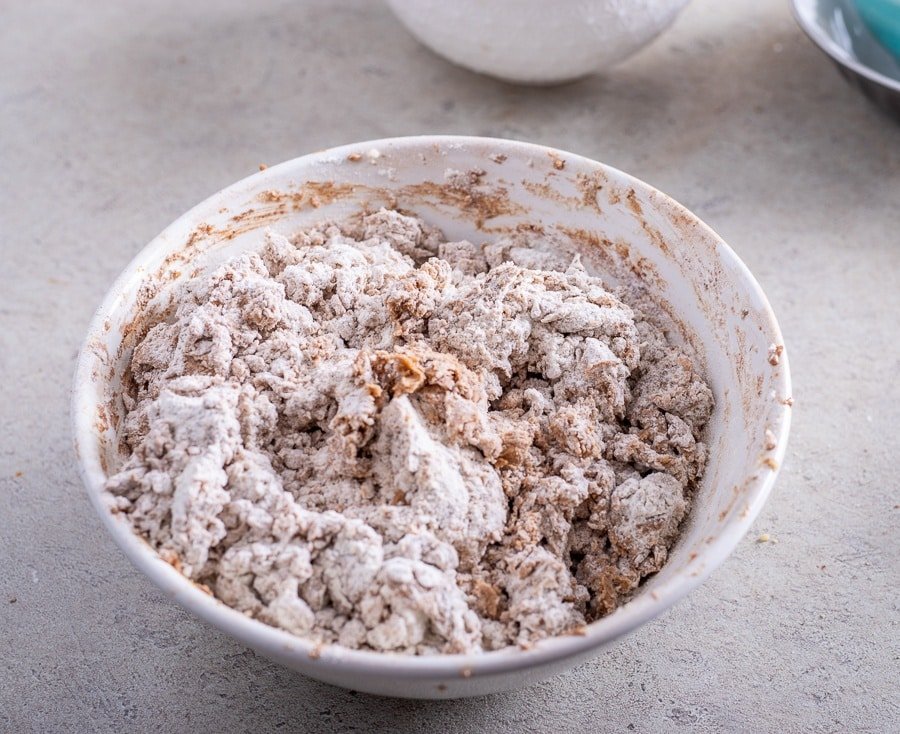 A bowl filled with flour and other ingredients for creating Croatian Paprenjaci, also known as Black Pepper Cookies.
