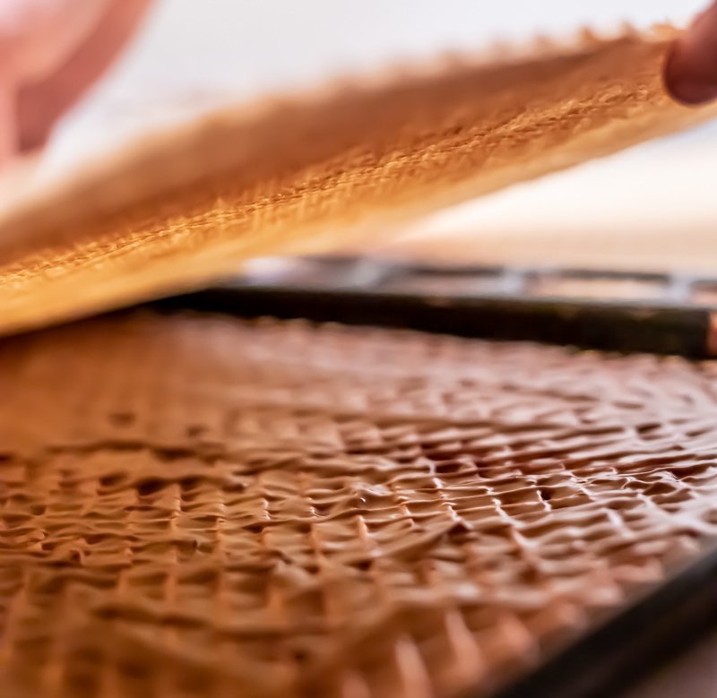 A person is making a chocolate waffle with Čokoladnom Karamel Kremom on a tray.