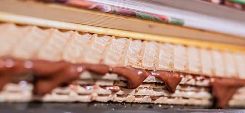 A close up of a waffle with chocolate and karamel kremom on it.