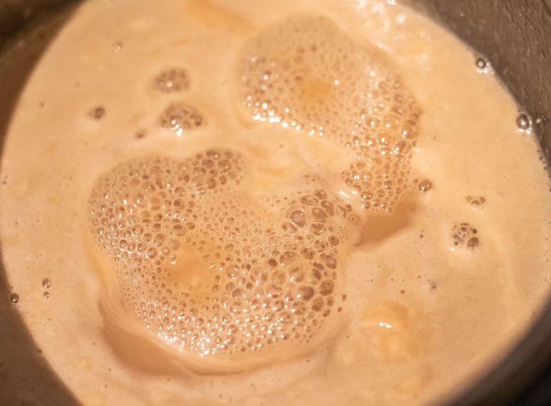 A close up of a pot with liquid in it, showing the process of how Oblatne cake is made.