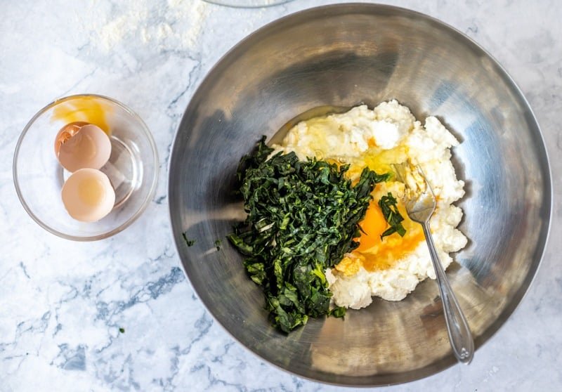A traditional Croatian recipe called Rudarska Greblica, featuring a bowl filled with eggs, spinach, and cheese.
