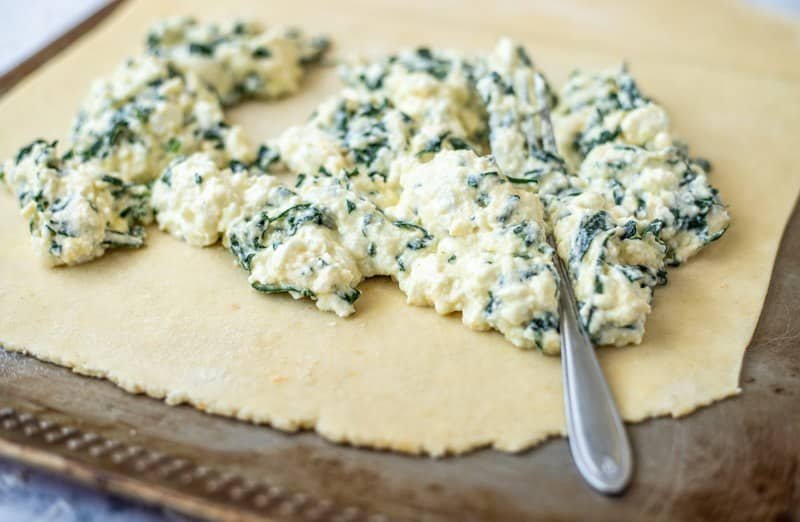 A Croatian recipe for Rudarska Greblica, a delicious pastry made with spinach and cheese baked on a baking sheet.