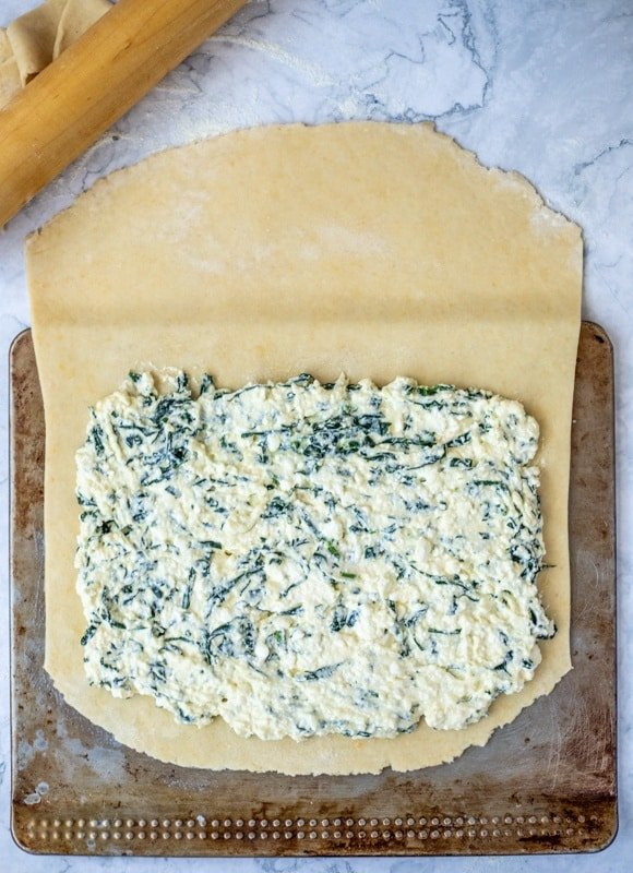 A Croatian recipe for Rudarska Greblica, a square of spinach cheesecake on a baking sheet.