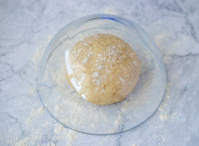 A traditional Croatian recipe, Rudarska Greblica, showcasing a ball of dough sitting in a glass bowl.