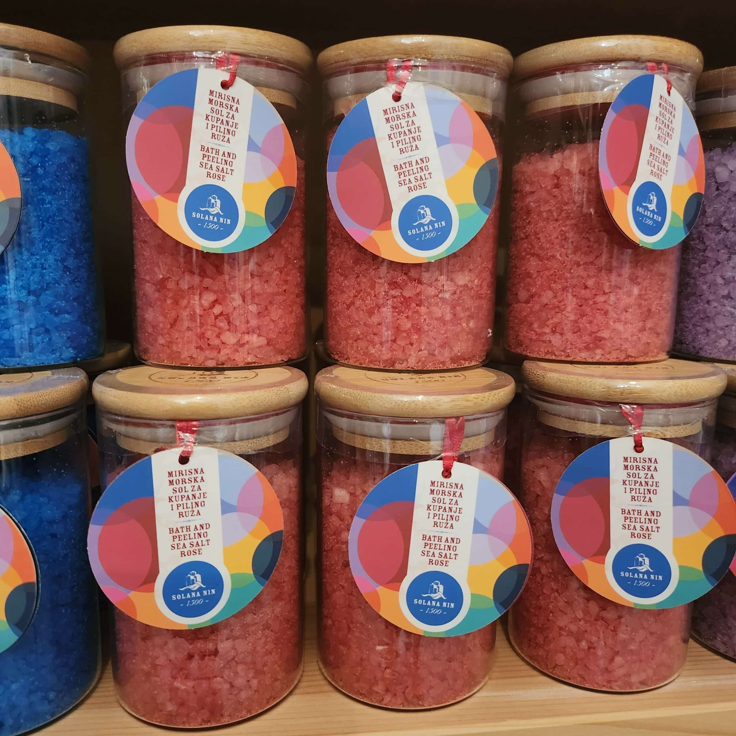 Vibrant jars of colorful bath salts elegantly displayed on a shelf.