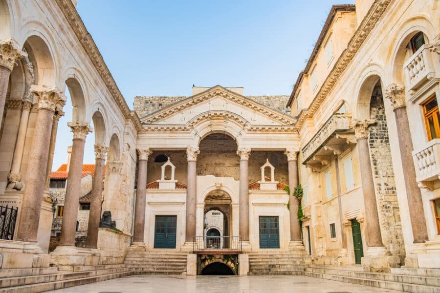 The Palace Of Diocletian - A stone building with columns and a stone walkway, recognized as one of the UNESCO World Heritage Sites in Croatia.