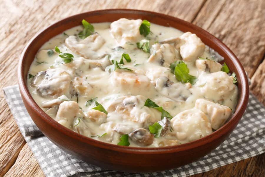 Ciulama chicken fricassee with white creamy sauce Romanian recipe closeup in the plate on the table