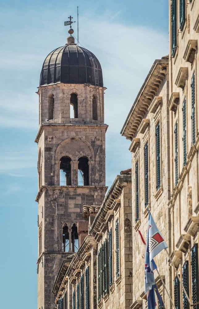 Discover the magnificent Bell tower of Franciscan Church and Monastery in Dubrovnik, Croatia on a building while exploring the delightful things to do in Dubrovnik.