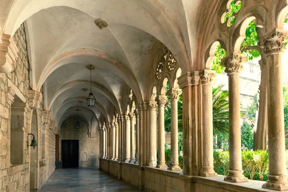 Explore Dubrovnik's stone walkway of Dubrovnik Dominican Monastery. Inner Courtyard adorned with arches, a must-visit attraction showcasing the architectural beauty of the city.