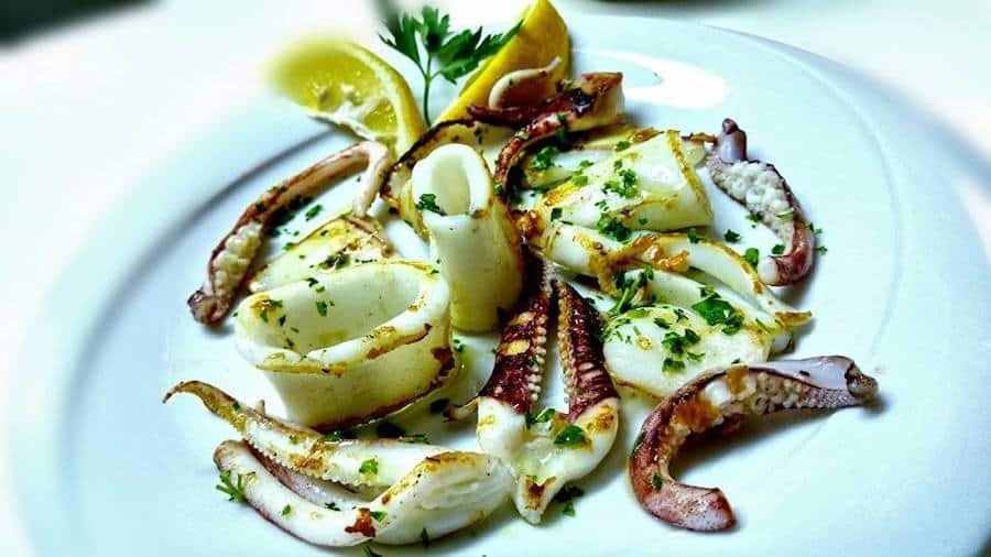 One of the things to do in Umag is enjoying a plate of delicious squid with lemon wedges.