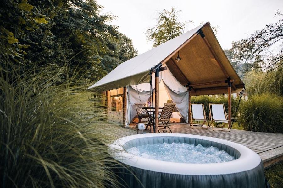 A glamping tent in Slovenia with a hot tub next to it.