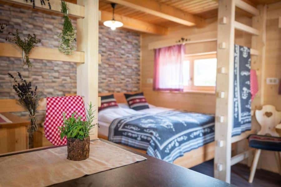 A bed or beds in a room with a wooden floor, ideal for glamping in Slovenia.