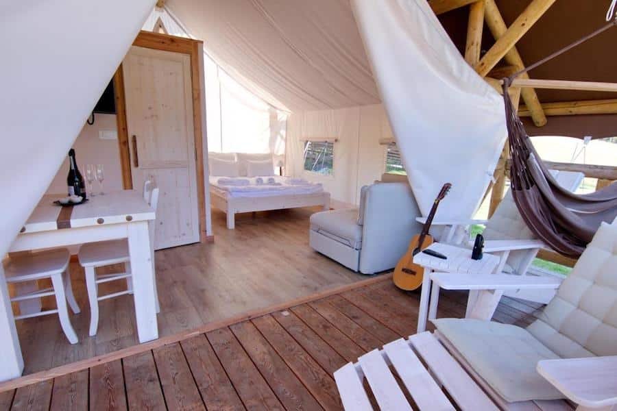 The inside of a glamping tent in Slovenia with chairs and a guitar.