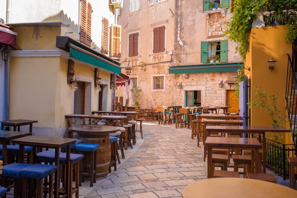 Looking for things to do in Porec? Check out the charming alleyway adorned with tables and chairs.