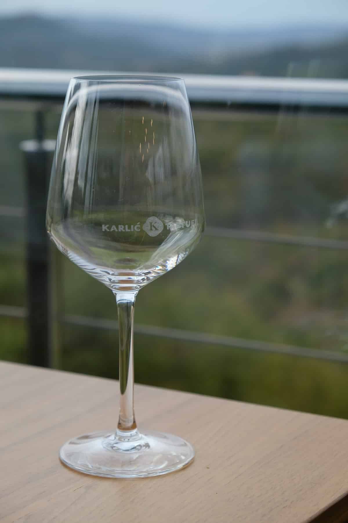 A wine glass with a view of Istria on a table at a winery in Croatia.