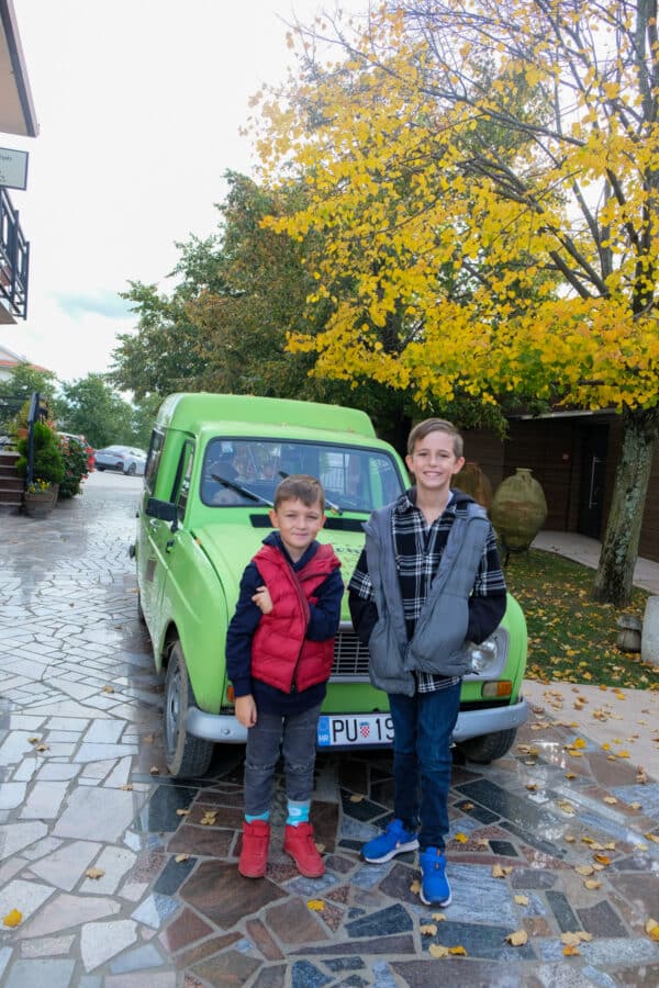 Two boys standing in front of a green van in Istria.