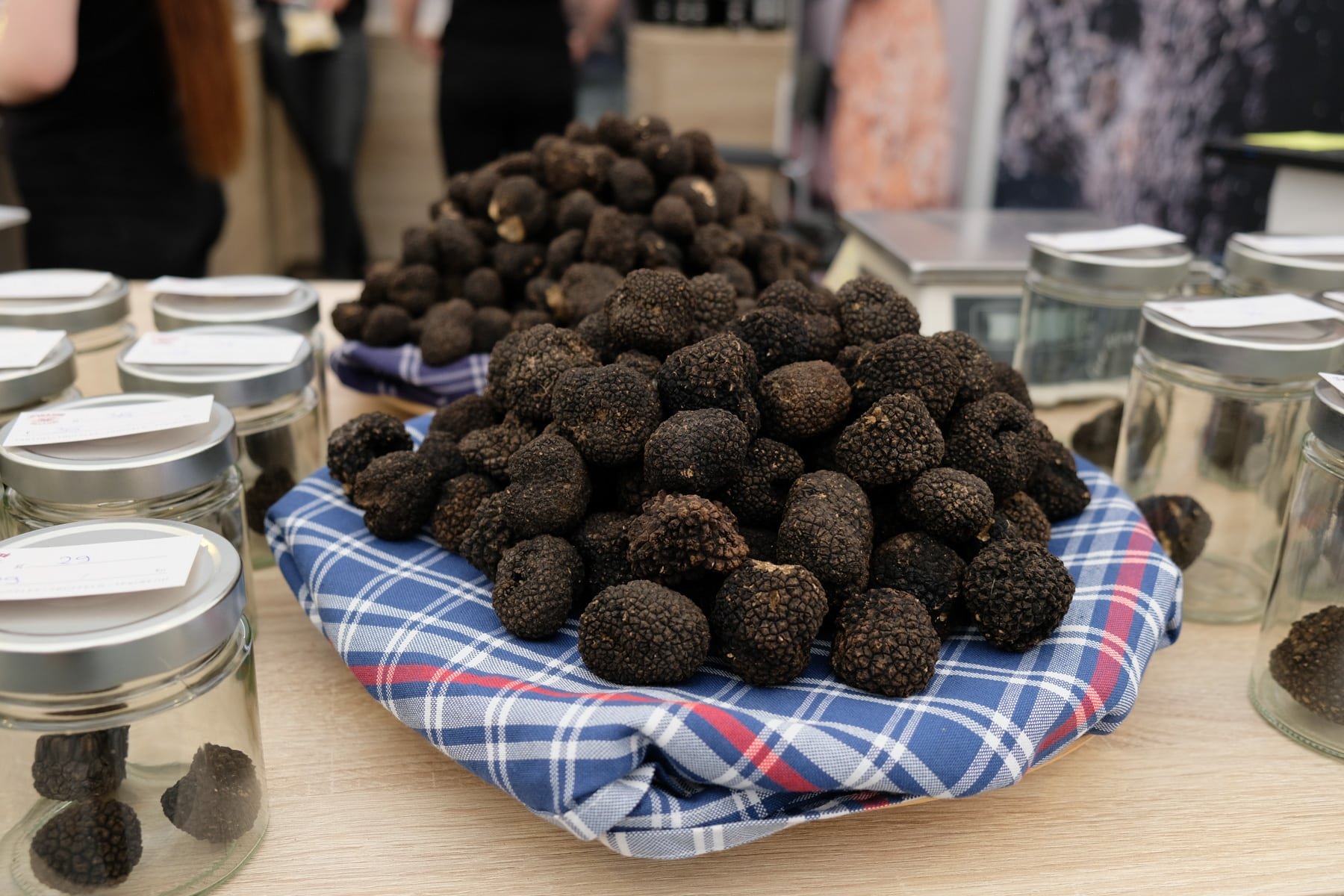 Black Istrian truffles in jars on a table.