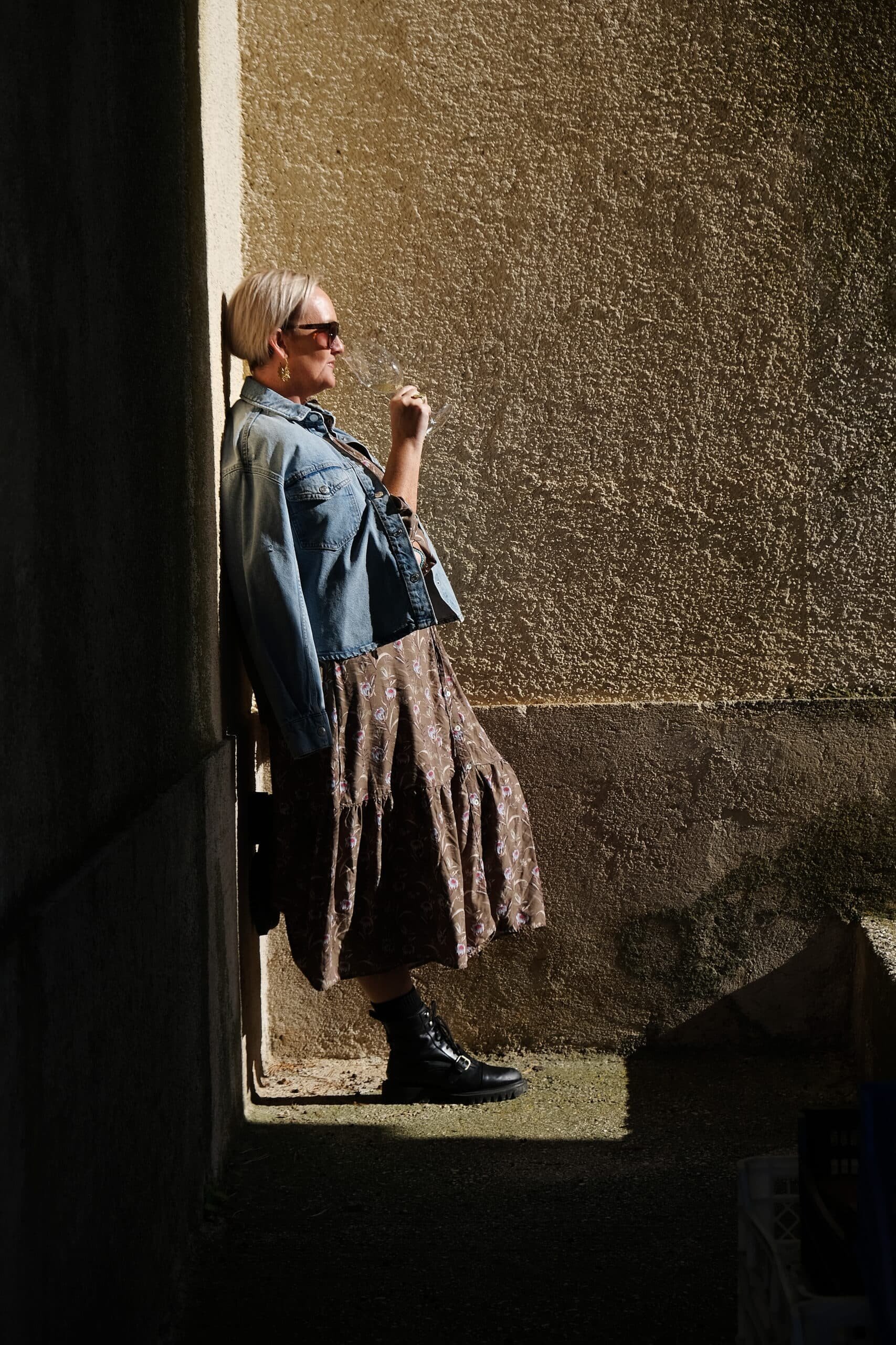 A woman istria leaning against a wall.