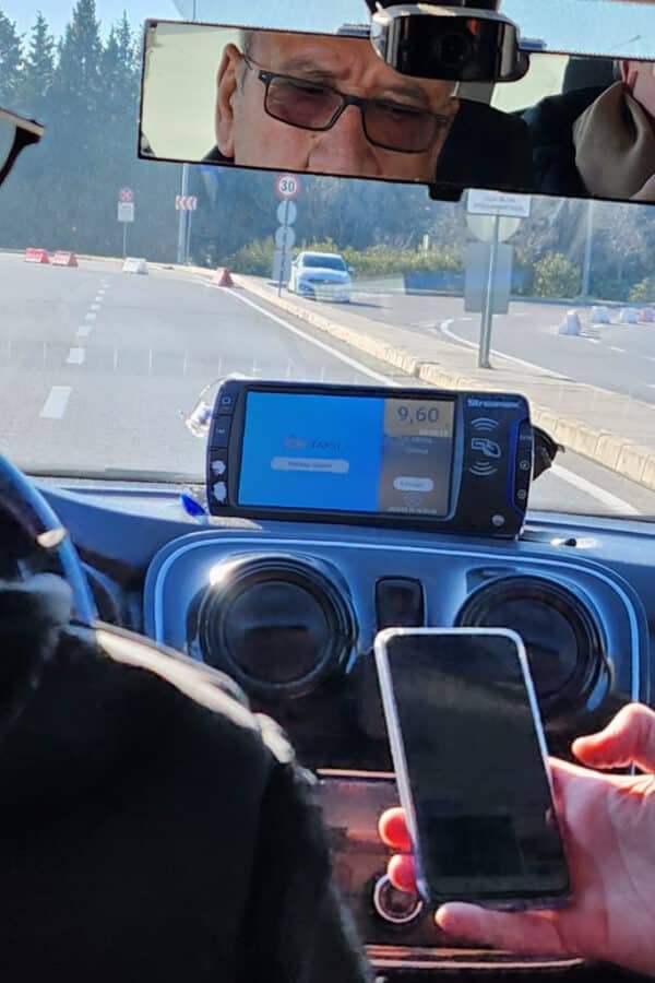 An Uber driver in Turkey is using a cell phone while driving.