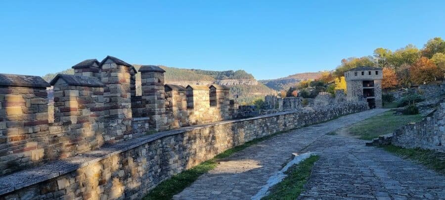 A picturesque stone path winding through the mountains to a majestic castle, offering an enchanting experience for visitors seeking things to do in Veliko Tarnovo.