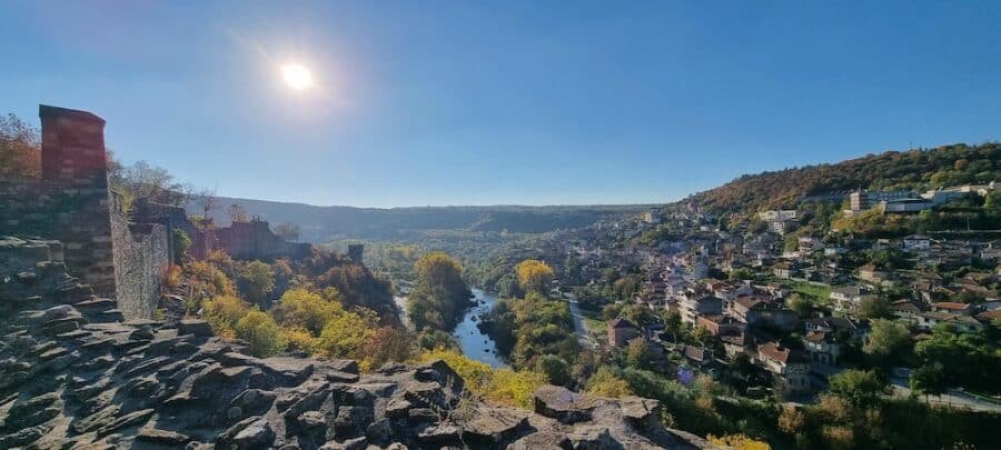 A breathtaking view from the top of a cliff offering panoramic vistas of a lush valley, showcasing one of the remarkable things to do in Veliko Tarnovo.