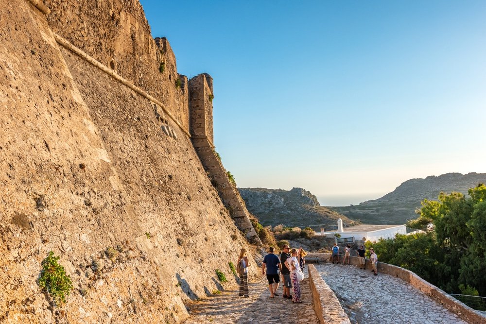 Tourists strolling along a historical old castle in Kythera island, Greece.