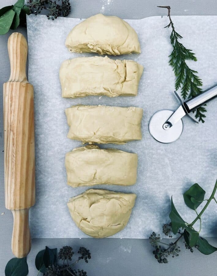 A cheese-filled crescent roll recipe with a rolling pin on a cutting board.
