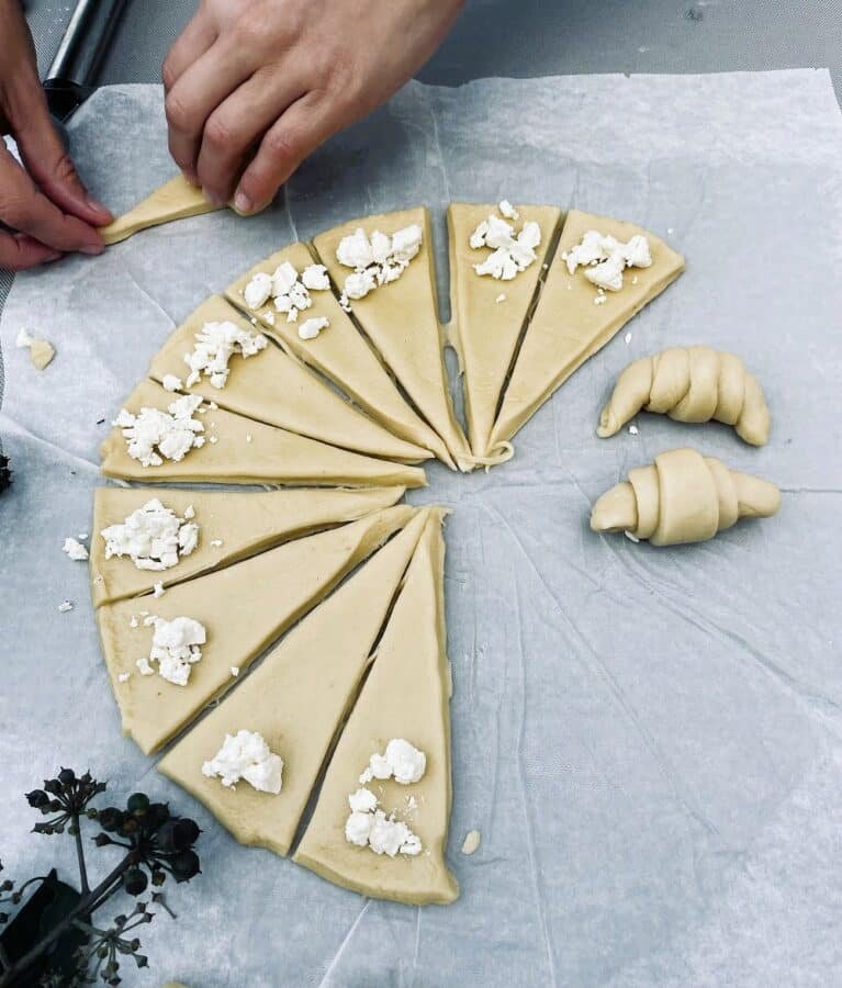 A person making kiflice sa sirom (cheese crescent rolls).