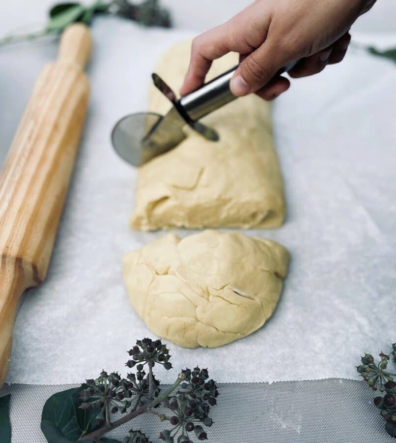 A person rolling out crescent roll dough with a rolling pin for a delicious recipe.