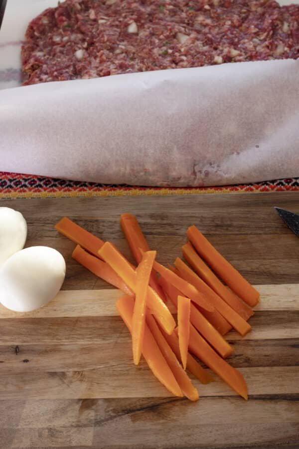 A cutting board with Rulo Stefani and carrots on it.