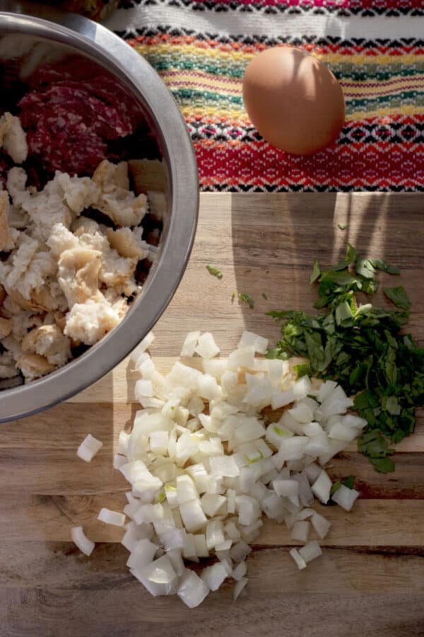 How To prepare a bowl of chopped onions on a wooden table for Rulo Stefani.