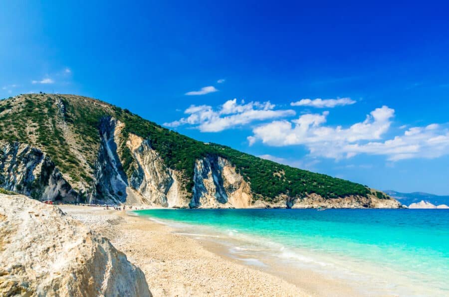 Visit Greece's largest islands for a breathtaking beach with clear blue water and a rocky cliff.