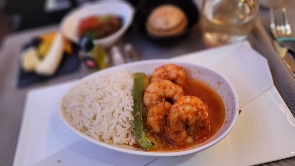 A bowl of rice and shrimp on a table, perfect for First Timers Guide on Turkish Airlines' Business Class flights.