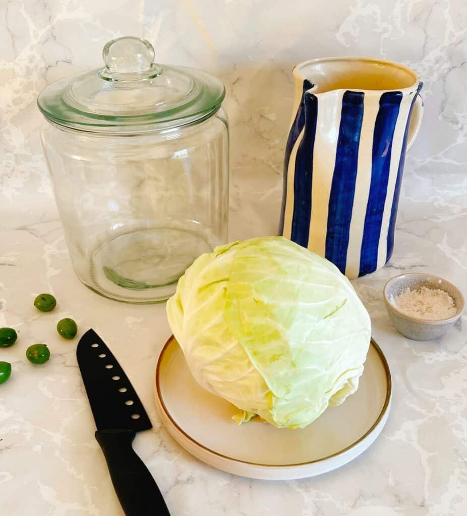 How to make sour cabbage in just a few steps! A cabbage on a plate, next to a jar of peas.