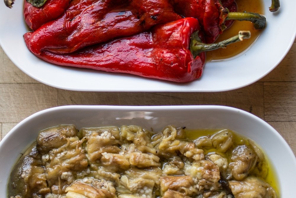Two bowls of Marinated Red Pepper and Eggplant Salad Traditional Turkish Mezes on a table.