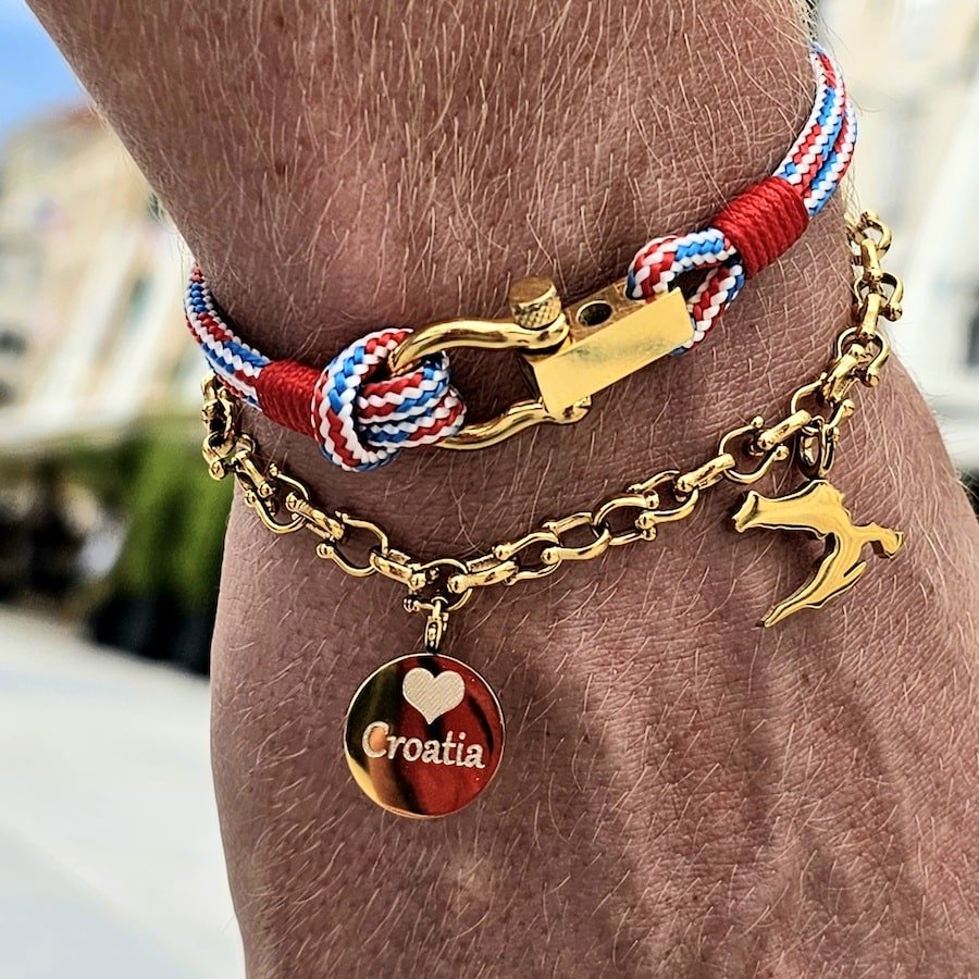 A person wearing a bracelet with two charms on it, wondering what to buy in Croatia.