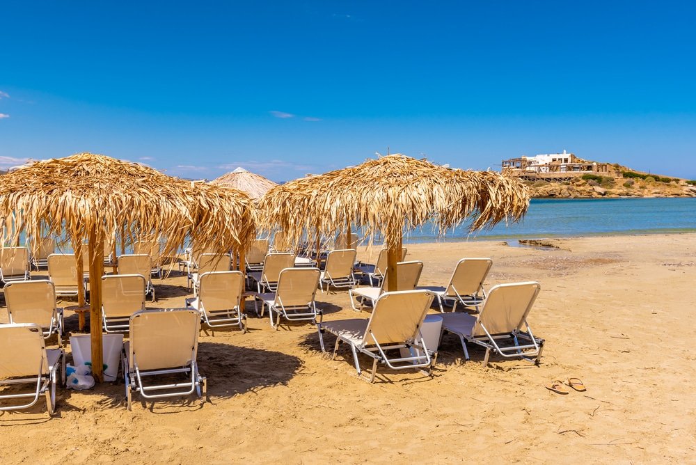 Best beaches on Naxos Island - Sunbeds with umbrellas on Agios Georgios beach, very popular resort on Naxos island, Greece.