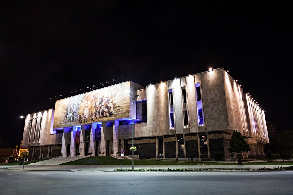 A large building at night in Tirana, offering an array of things to do.