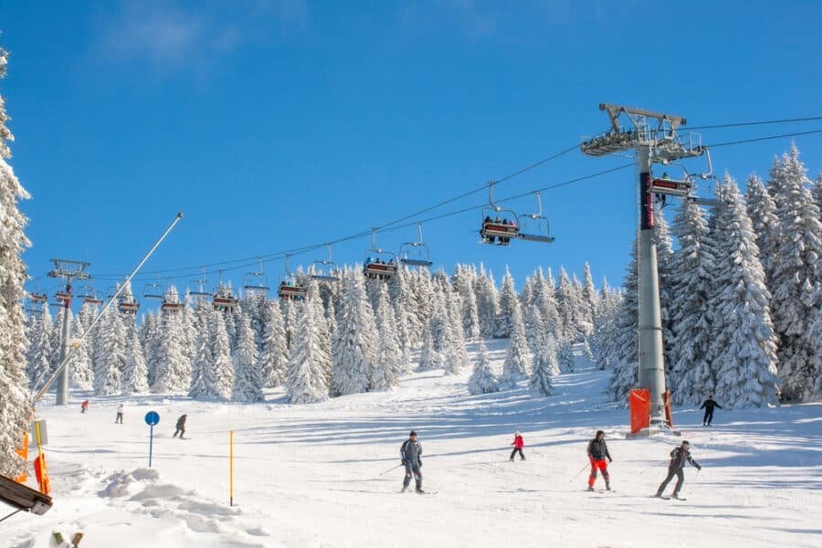 A group of people skiing on a snowy Kopaonik ski resort in Serbia.