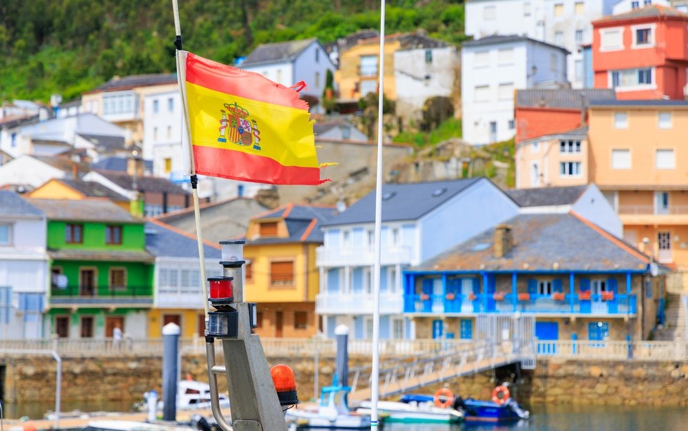 Greece or spain, how to choose. Spanish flag in galicia village with colorful houses- Travel in Spain