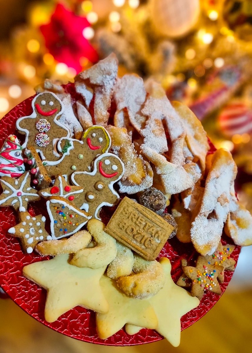 Christmas cookies on a red plate in front of a Christmas tree, evoking the festive atmosphere of Advent in Zagreb.