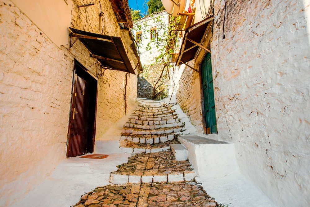 A narrow street with a stone path leading to a door, in Berat Albania