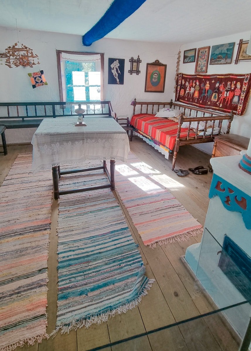 A room with a table and chairs and a rug in the Dimitrie Gusti National Village Museum