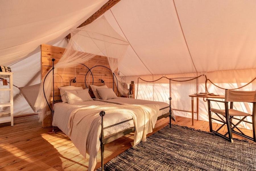 A glamping tent in Croatia equipped with a comfortable bed and a functional desk.